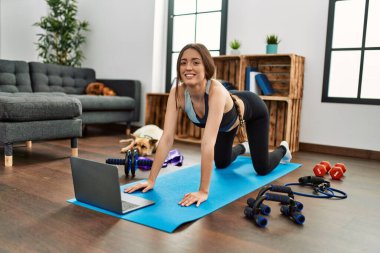 Evde esneme kursu aldığından emin bir şekilde gülümseyen genç İspanyol kadın.