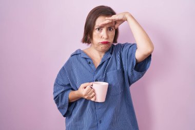 Orta yaşlı Latin bir kadın kahve içiyor. Alnındaki sorun yüzünden endişeli ve stresli. Kriz için endişeli. 