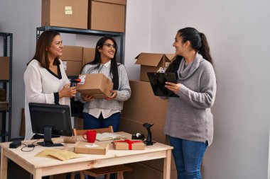 Three woman ecommerce business workers scanning package working at office