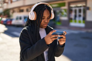 African american woman playing video game at street