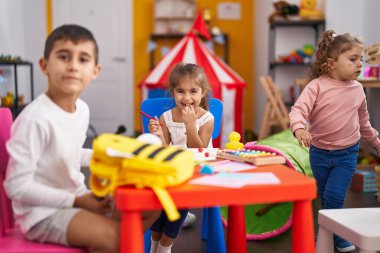 Group of kids preschool students sitting on table drawing on paper at kindergarten