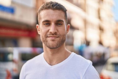 Young caucasian man smiling confident standing at street