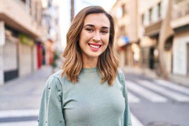 Sokakta kendinden emin gülümseyen genç bir kadın