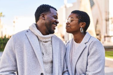 Erkek ve kadın bir arada durarak gülümsüyor.