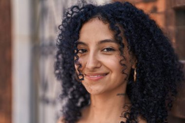 Sokakta kendine gülen genç İspanyol kadın.