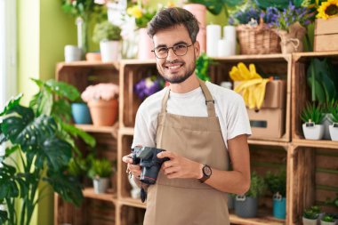 Çiçekçide çiçek buketine resim yapan İspanyol genç adam.