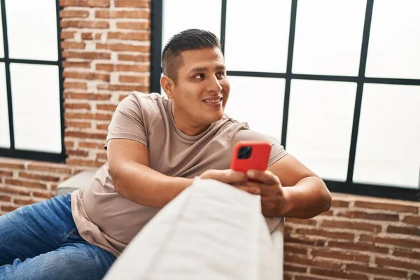 Ung Latin Man Med Smartphone Sitter Soffan Hemma — Stockfoto