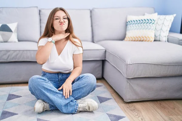 Young Caucasian Woman Sitting Floor Living Room Cutting Throat Hand — Foto Stock