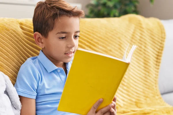 Adorable Hispanic Boy Reading Book Sitting Sofa Home — ストック写真