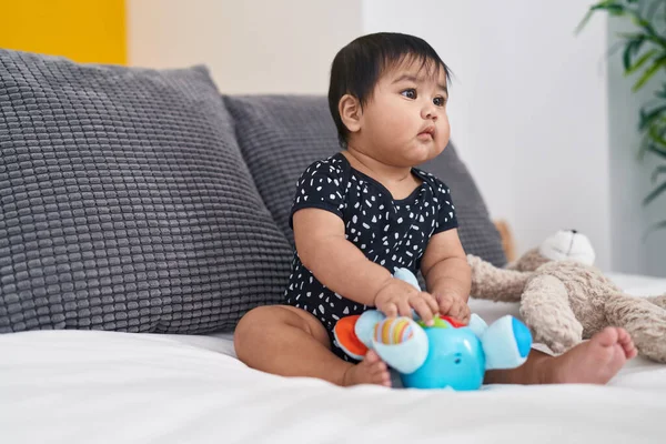 Suloinen Latino Vauva Leikkii Nukeilla Istuu Sängyssä Makuuhuoneessa — kuvapankkivalokuva