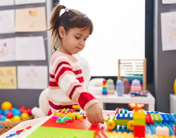 Adorable Hispanic Girl Playing Construction Blocks Standing Kindergarten — Zdjęcie stockowe