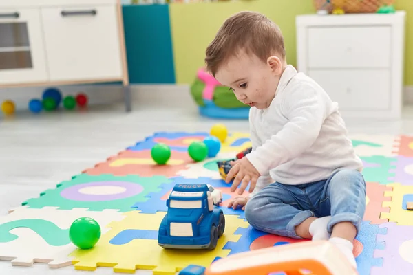 可愛い白人の赤ん坊遊びとともにトラックおもちゃで床に座って幼稚園 — ストック写真
