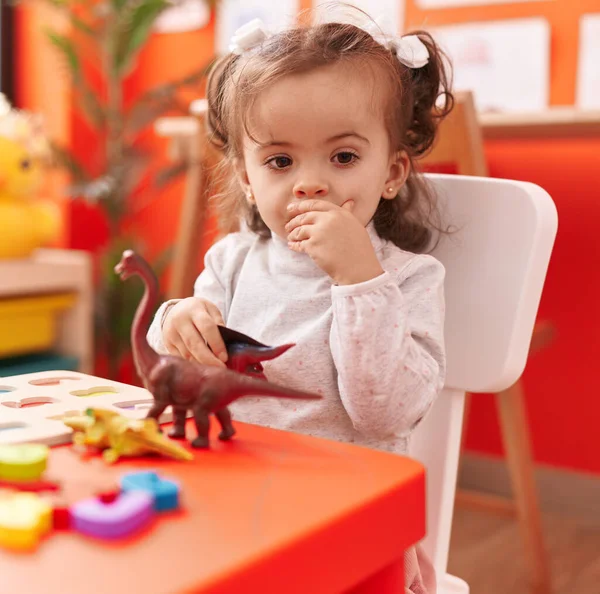 유치원 테이블에 앉아서 장난감을 가지고 스러운 잠꾸러기 — 스톡 사진