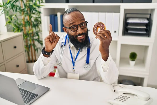 African American Man Working Dietitian Clinic Holding Doughnut Surprised Idea — Stockfoto