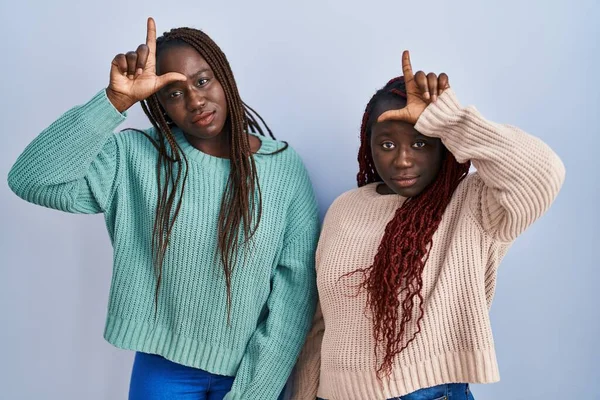 Two African Woman Standing Blue Background Making Fun People Fingers — Stok fotoğraf