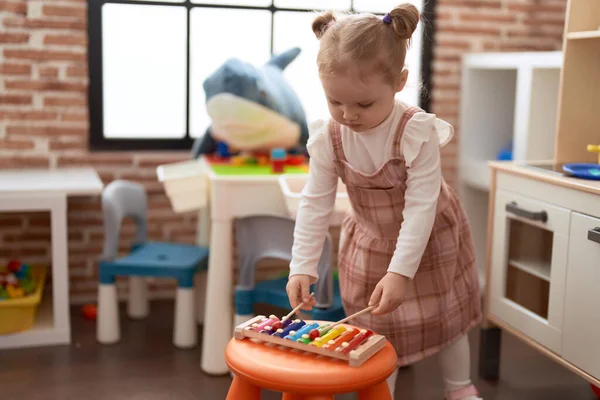 可爱的高加索女孩站在幼儿园里弹奏木琴 — 图库照片