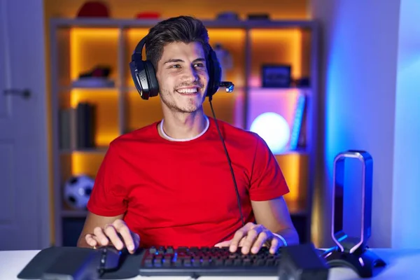 Young Hispanic Man Playing Video Games Looking Away Side Smile — Stockfoto