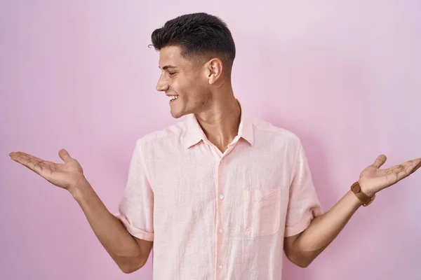 Joven Hombre Hispano Pie Sobre Fondo Rosa Sonriendo Mostrando Ambas — Foto de Stock