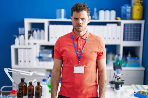 Young Hispanic Man Working Scientist Laboratory Skeptic Nervous Frowning Upset — стоковое фото