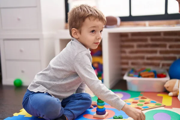 幼稚園で遊んで床に座っている愛らしい幼児 — ストック写真