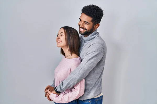 Young Hispanic Couple Standing Together Looking Side Relax Profile Pose — Stockfoto