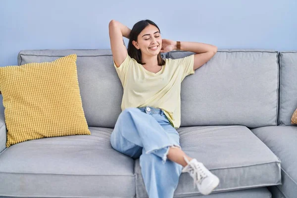 Young Hispanic Woman Relaxed Hands Head Sitting Sofa Home — Stockfoto