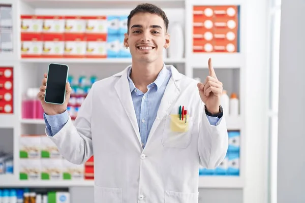 Hombre Hispano Guapo Que Trabaja Farmacia Mostrando Pantalla Del Teléfono —  Fotos de Stock