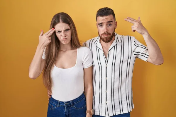 Young Couple Standing Yellow Background Shooting Killing Oneself Pointing Hand — Foto Stock