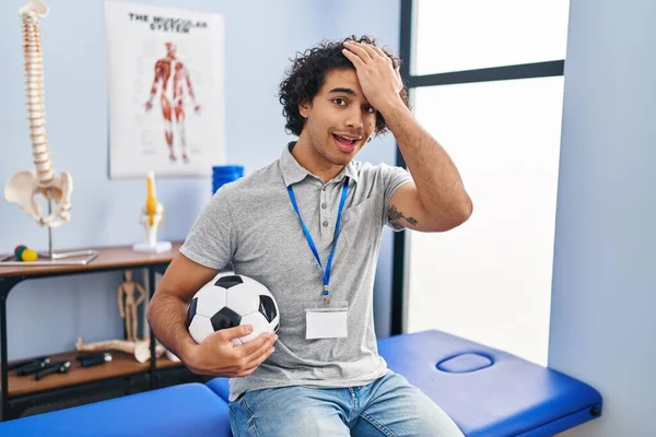 Hispanic Man Curly Hair Working Football Physiotherapist Surprised Hand Head — Stockfoto
