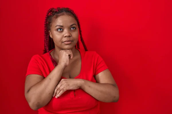African American Woman Braided Hair Standing Red Background Hand Chin — Stok fotoğraf