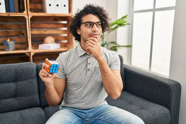 Hispanic Man Curly Hair Playing Colorful Puzzle Cube Intelligence Game — Stockfoto