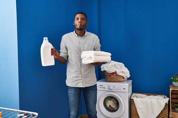 African American Man Holding Clean Towels Making Fish Face Mouth — Stockfoto