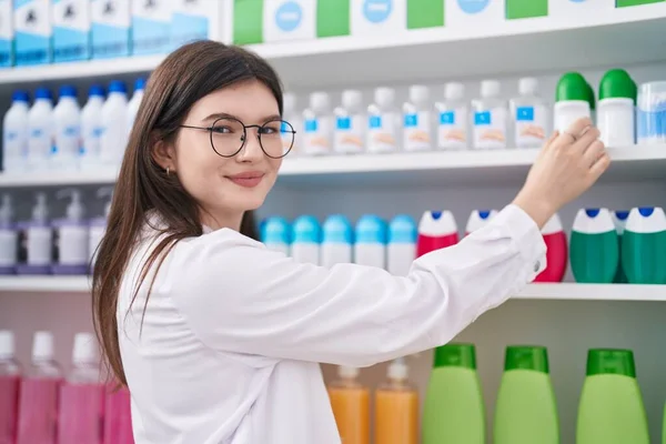 若い白人女性薬剤師は薬局で棚に自信を持って保持薬を笑顔 — ストック写真