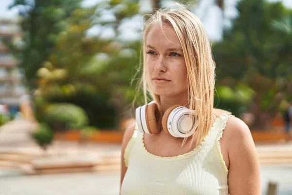 Jonge Blonde Vrouw Draagt Koptelefoon Met Ontspannen Uitdrukking Het Park — Stockfoto