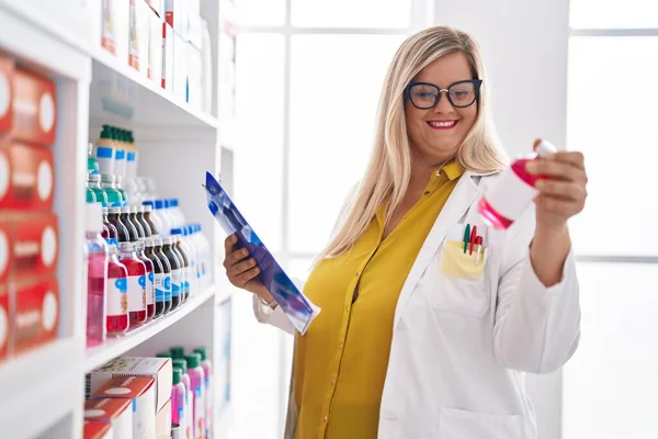 Young Woman Pharmacist Reading Document Holding Medication Bottle Pharmacy — Foto Stock