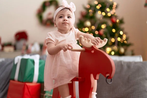 愛らしい幼児遊びます上のロッキングトナカイによってクリスマスツリーに家 — ストック写真