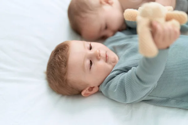 Dwoje Małych Dzieci Leżących Łóżku Bawiących Się Pluszowym Miśkiem Sypialni — Zdjęcie stockowe