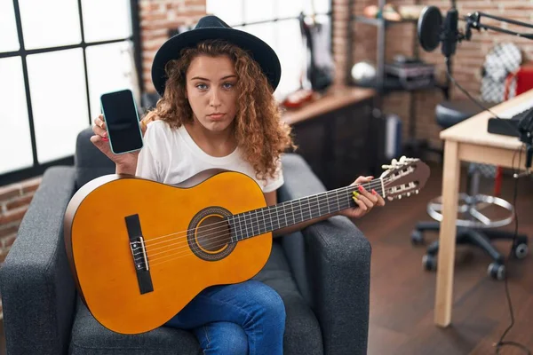 Young Caucasian Woman Playing Classic Guitar Music Studio Holding Smartphone — Stock fotografie