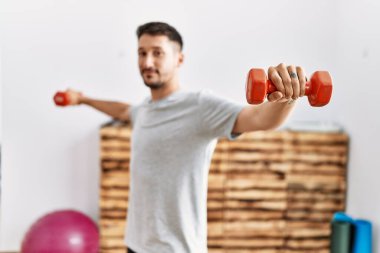 Genç İspanyol adam gülümsüyor spor merkezinde kendine güvenen bir antrenman