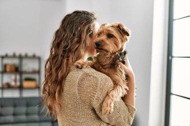 Genç, güzel, İspanyol bir kadın. Köpeğine sarılıyor.