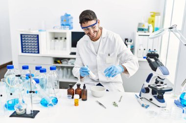 Laboratuvarda bilimsel havan topu kullanan yakışıklı İspanyol.