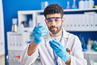 Young arab man wearing scientist uniform working at laboratory