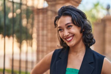 Young beautiful hispanic woman smiling confident looking to the side at street
