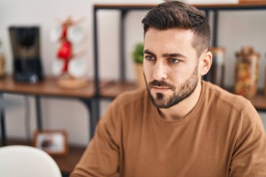 Genç İspanyol adam evde rahat bir ifadeyle masada oturuyor.