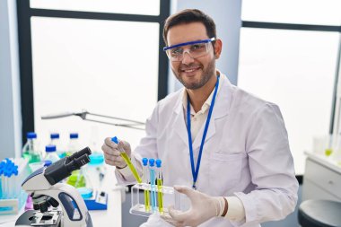 Laboratuvarda test tüpleri tutan genç İspanyol bilim adamı.