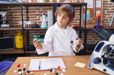 Sınıfta molekülleri tutan sevimli beyaz çocuk.