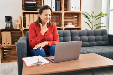 Middle age hispanic woman psychologist having online therapy session at psychology center