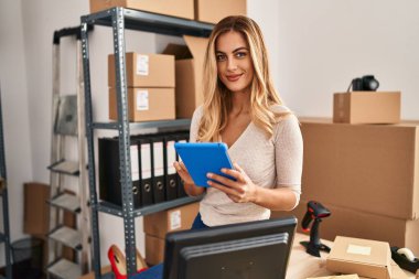 Ofiste çalışan genç sarışın iş kadını touchpad kullanıyor.