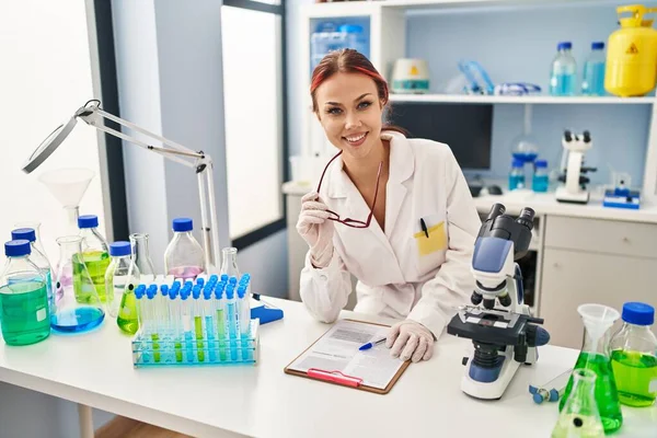 Молода Біла Жінка Науковець Посміхається Впевнено Тримає Окуляри Лабораторії — стокове фото