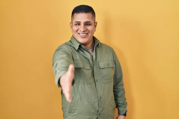 Hispanic Young Man Standing Yellow Background Smiling Friendly Offering Handshake — Stock fotografie